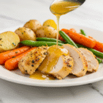 Crockpot Veggies and Chicken: The Ultimate One-Pan Weeknight Lifesaver 2 A close-up of a finished crockpot veggies and chicken on a white plate, with a lemon herb sauce being drizzled over sliced, juicy chicken breast.