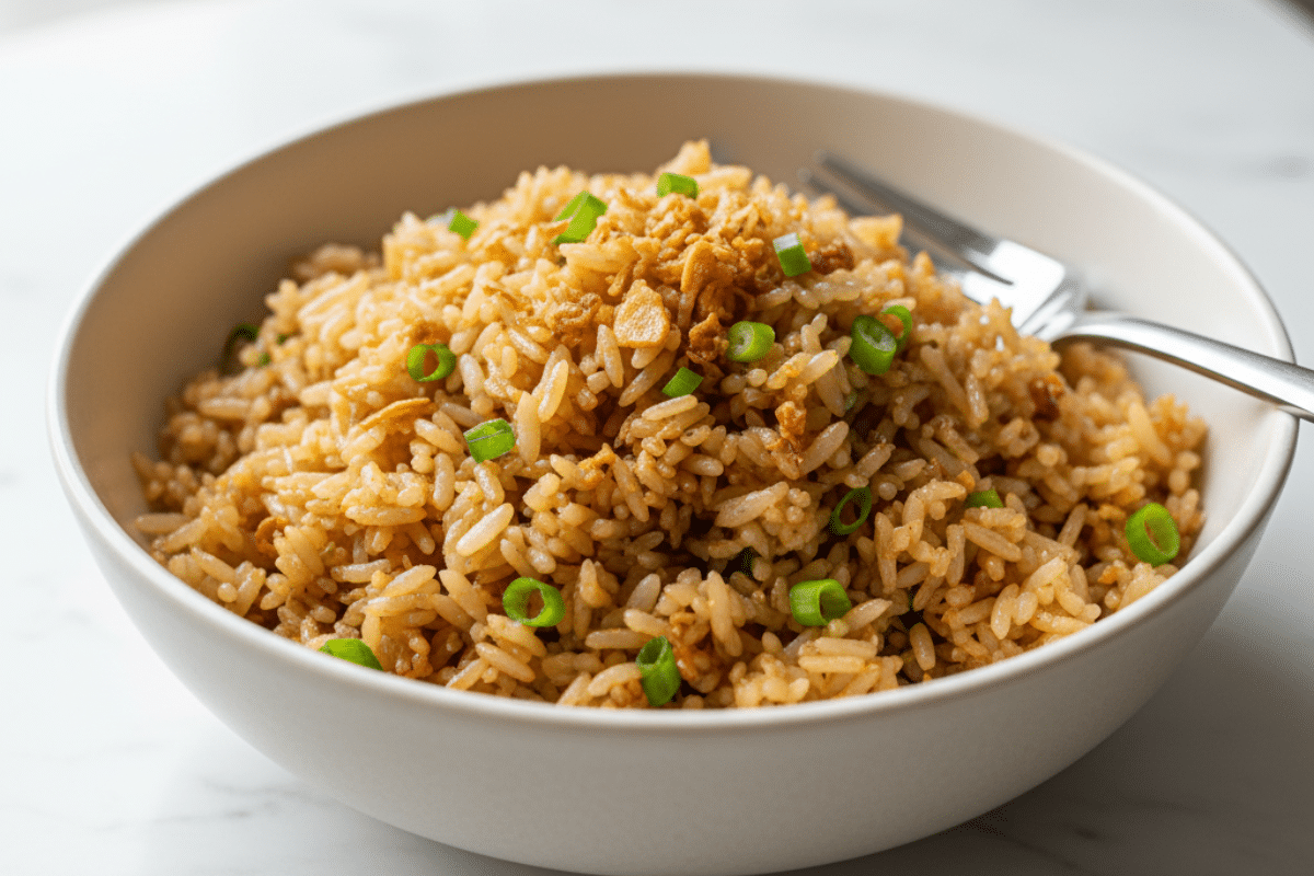 A Perfect Bowl of Garlic Fried Rice A finished bowl of the easy garlic fried rice recipe, garnished with crispy garlic and green onions, ready to be served.