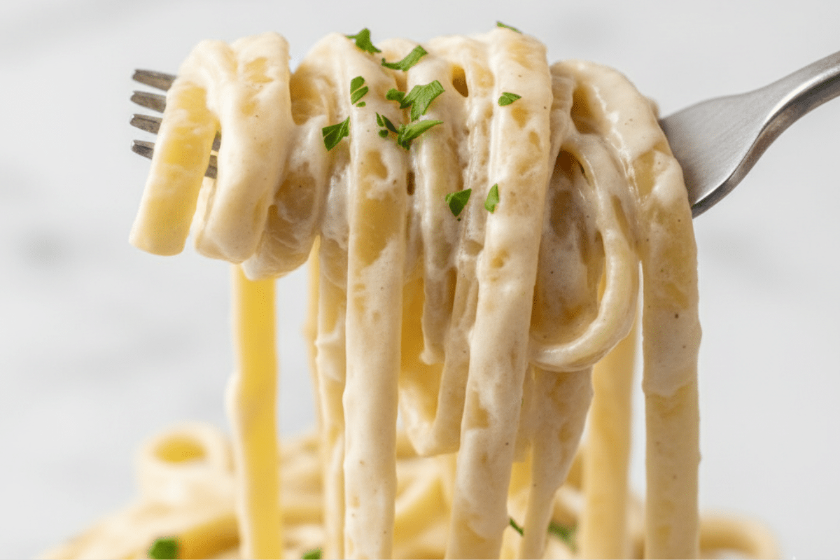 Fork twirling noodles coated in the creamy sauce for one pot creamy garlic pasta.