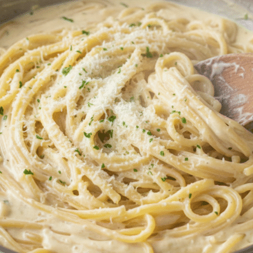Thick, creamy one pot creamy garlic pasta simmering in a stainless steel skillet.