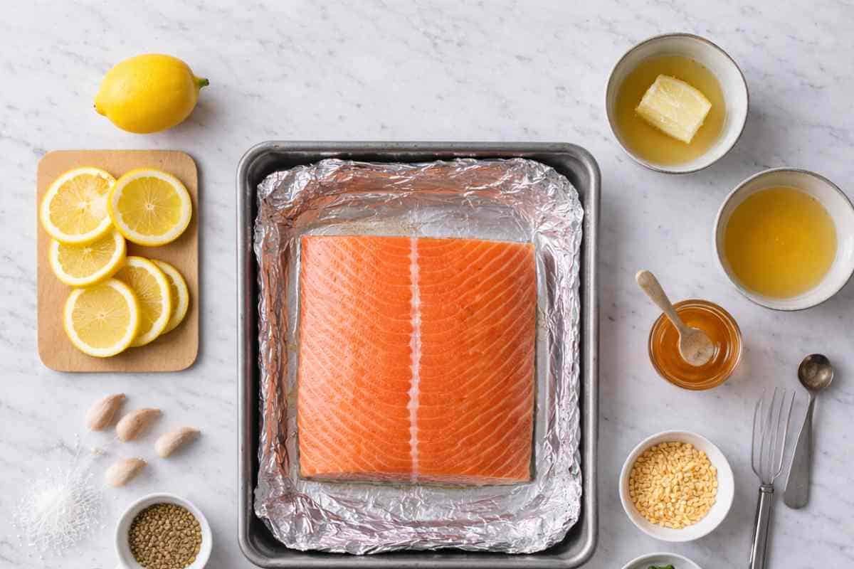 Ingredients for Sheet Pan Lemon Garlic Butter Salmon including fresh salmon fillet, lemons, butter, garlic and honey