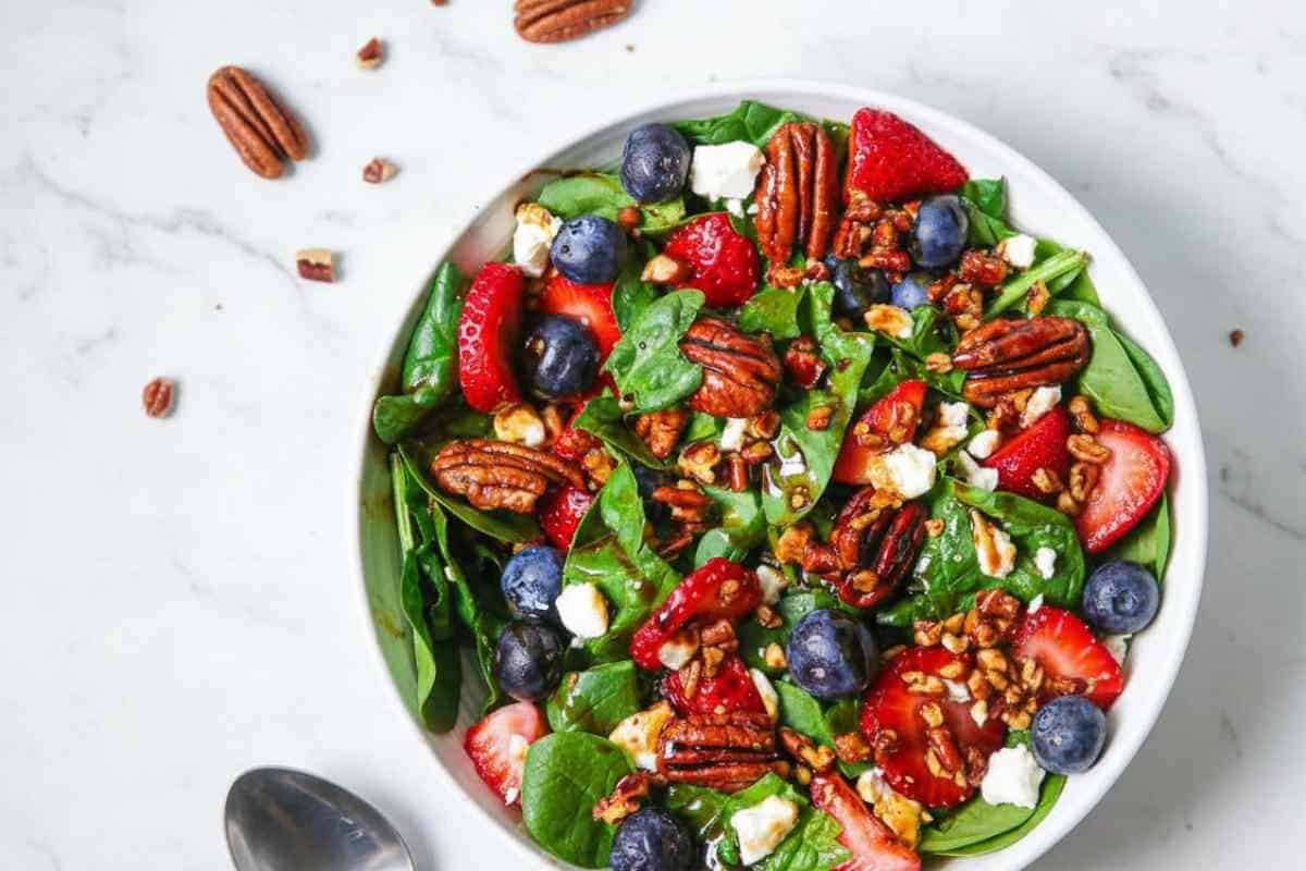 Individual serving of strawberry spinach salad with balsamic glaze drizzle
